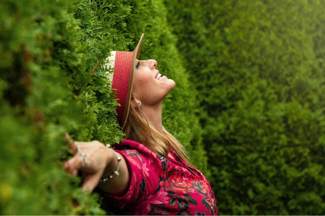 woman leaning on bushes