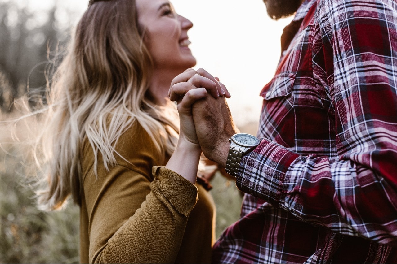 A couple dances in a fall pasture.