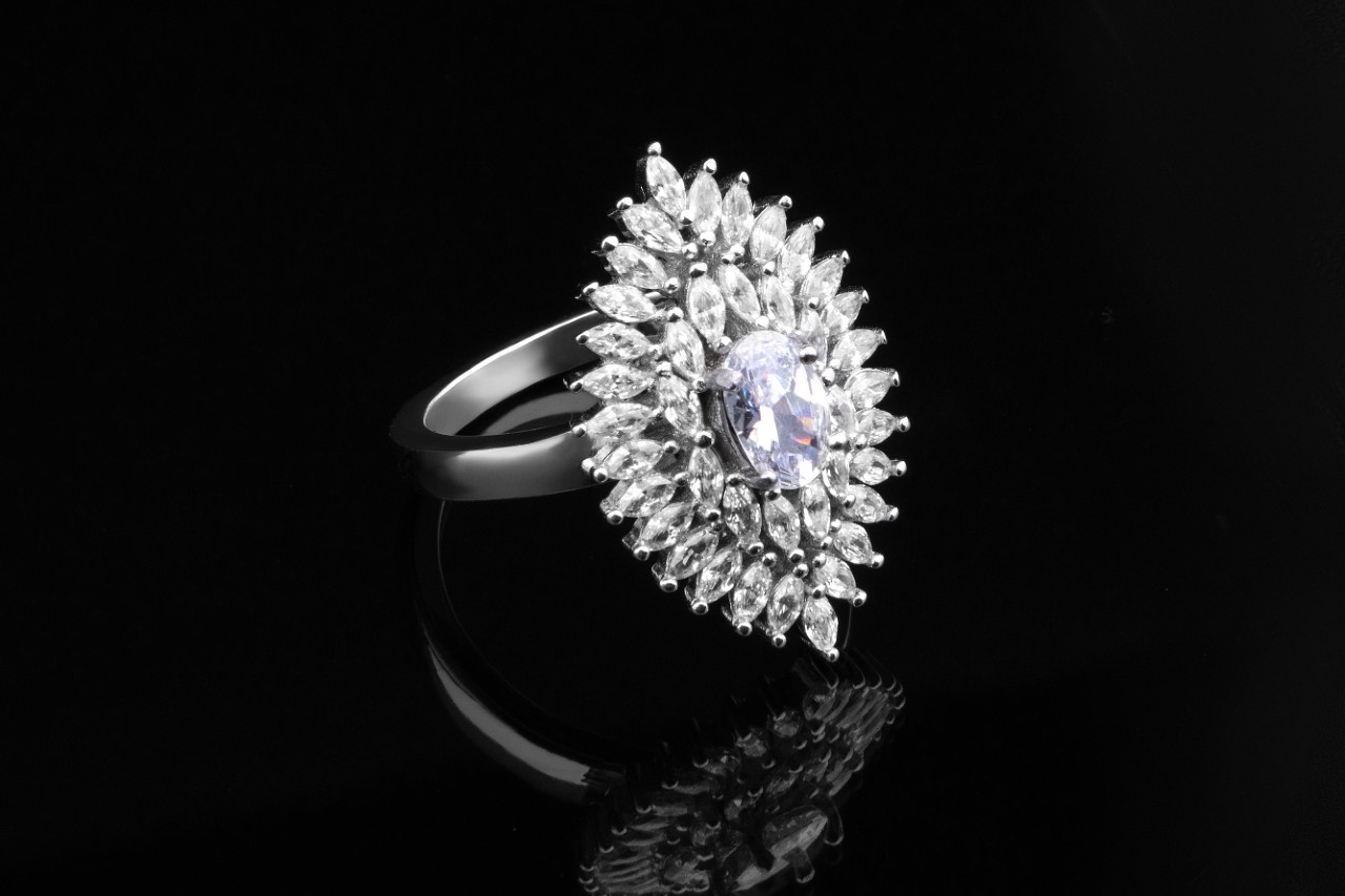 A stunning diamond ring with several marquise cut diamonds surrounding an oval cut center stone, all secured with prong settings.