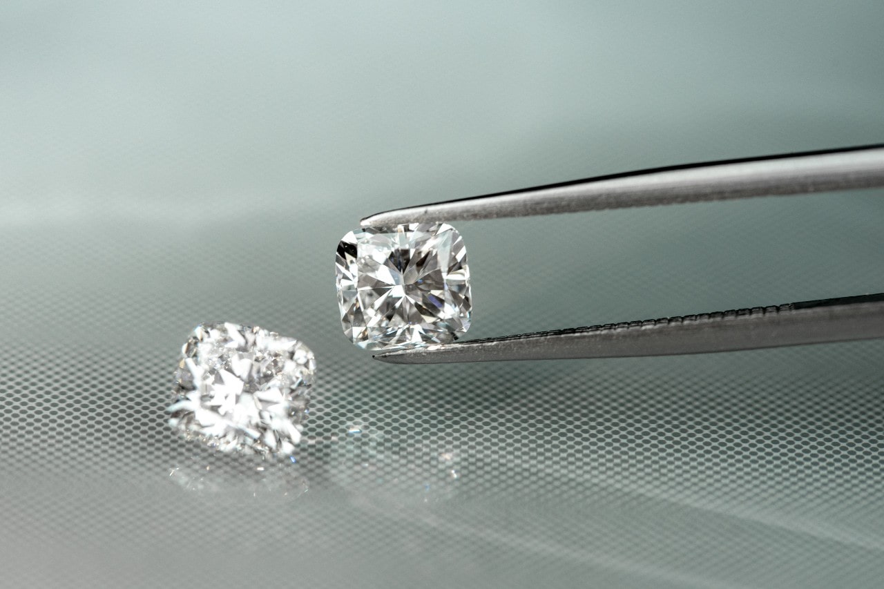 A couple cushion cut diamonds being examined by a jeweler