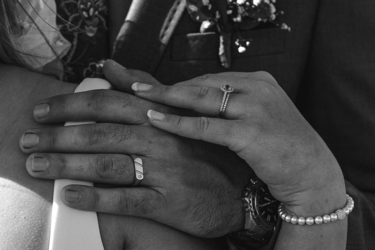 a bride and groom touching hands, the bride wearing a matching bridal stack set