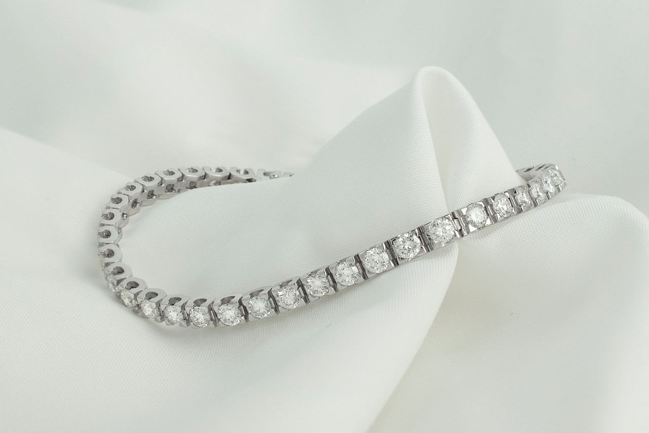 A diamond tennis bracelet on a piece of white fabric