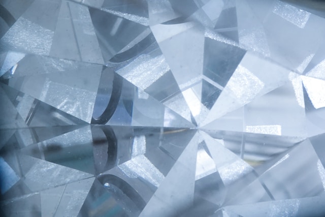 A close-up of the facets of a glistening diamond.