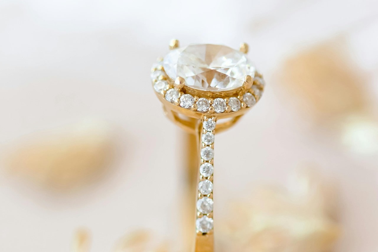 A close-up of an opulent halo engagement ring with side stones.