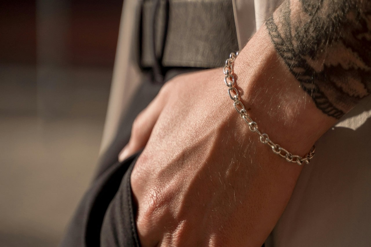 A close-up of a person’s wrist, adorned with an elegant gold bracelet.