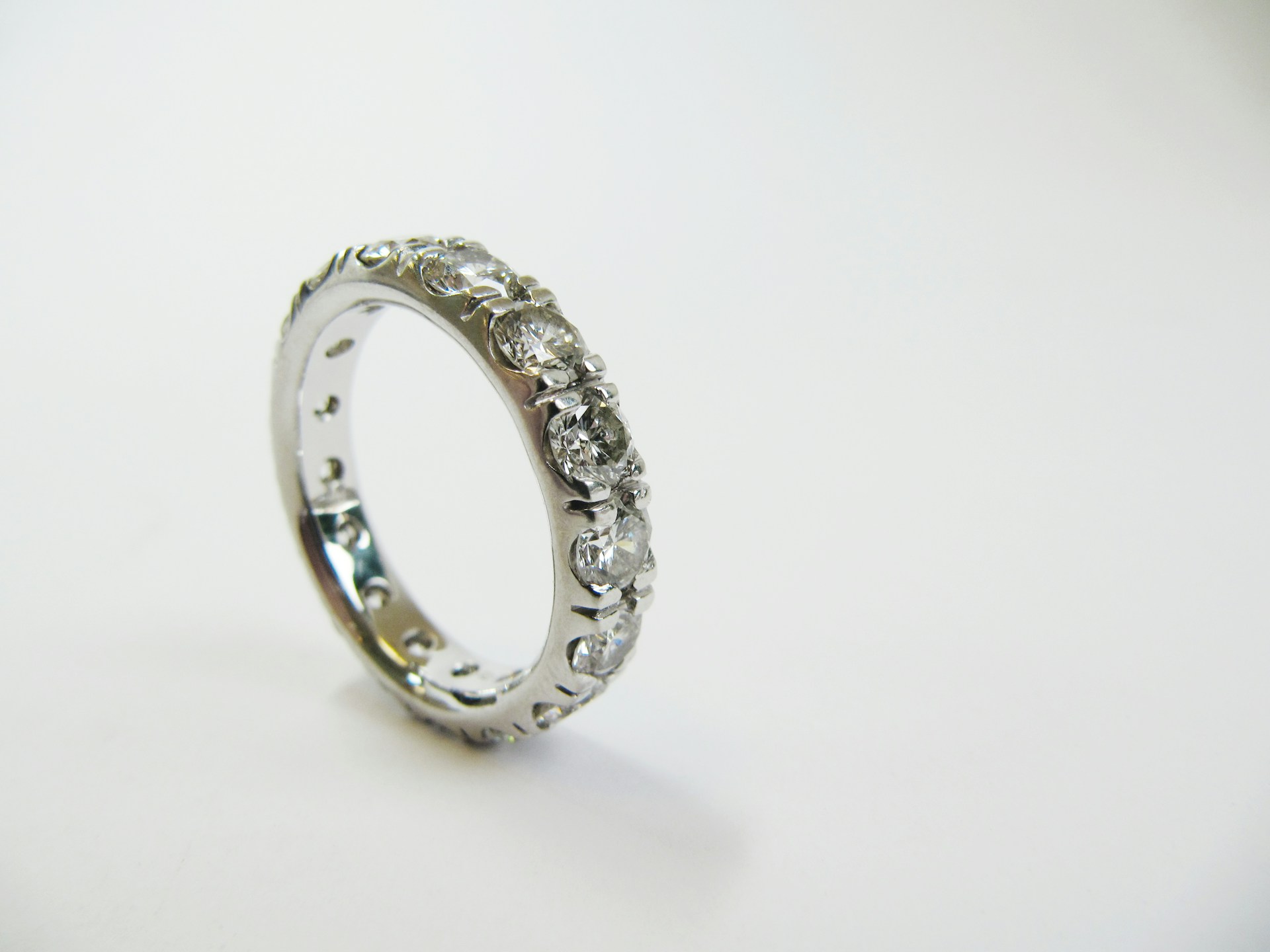 a white gold wedding band with prong set round cut diamonds