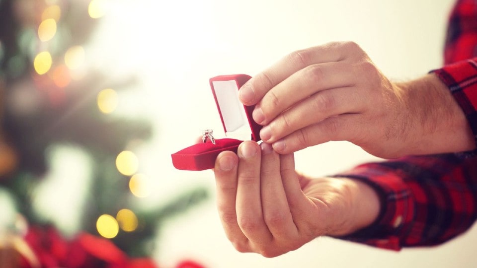 A man pops the question to his beloved with a diamond ring on Christmas Day.
