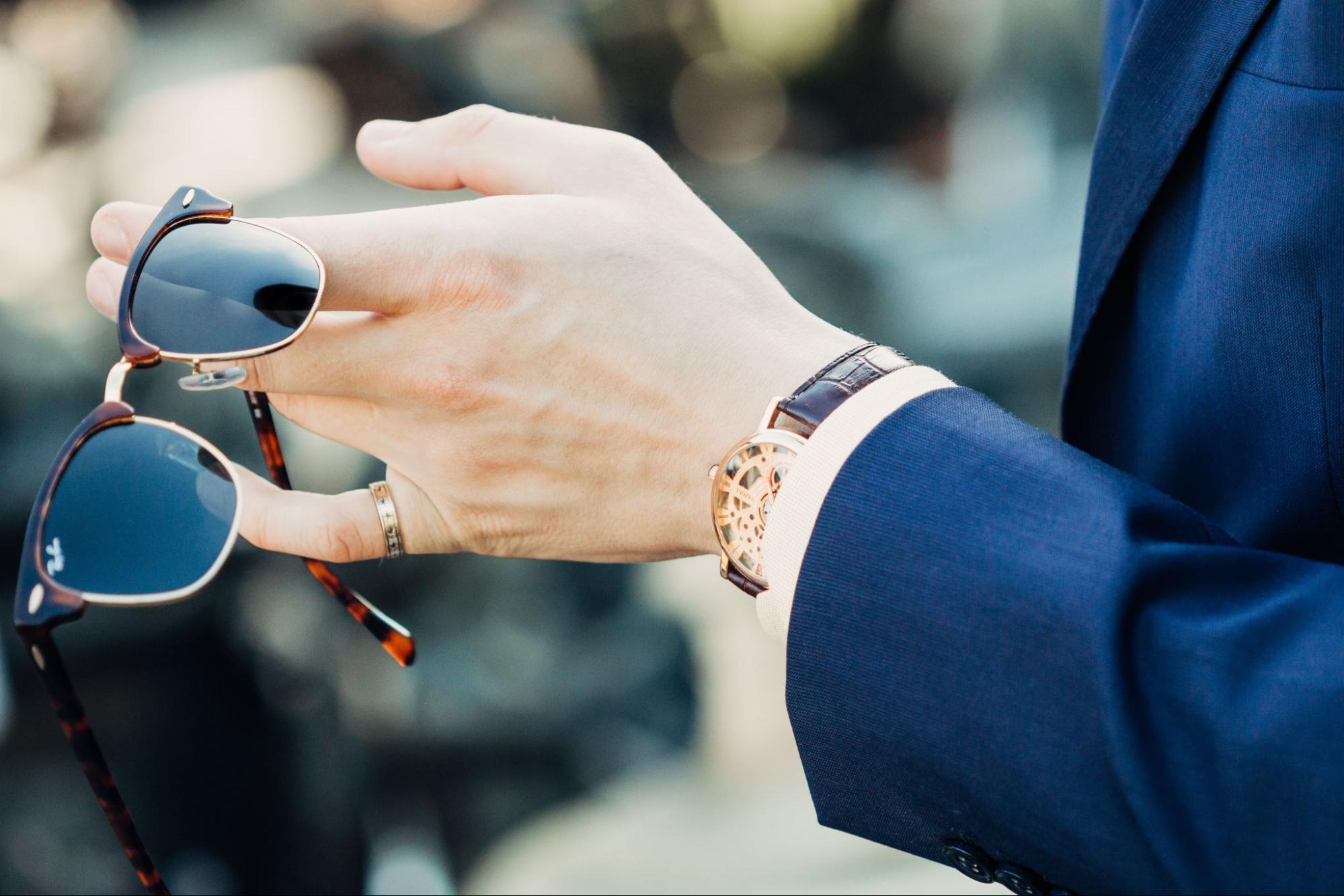 man with glasses with watch under sleeve