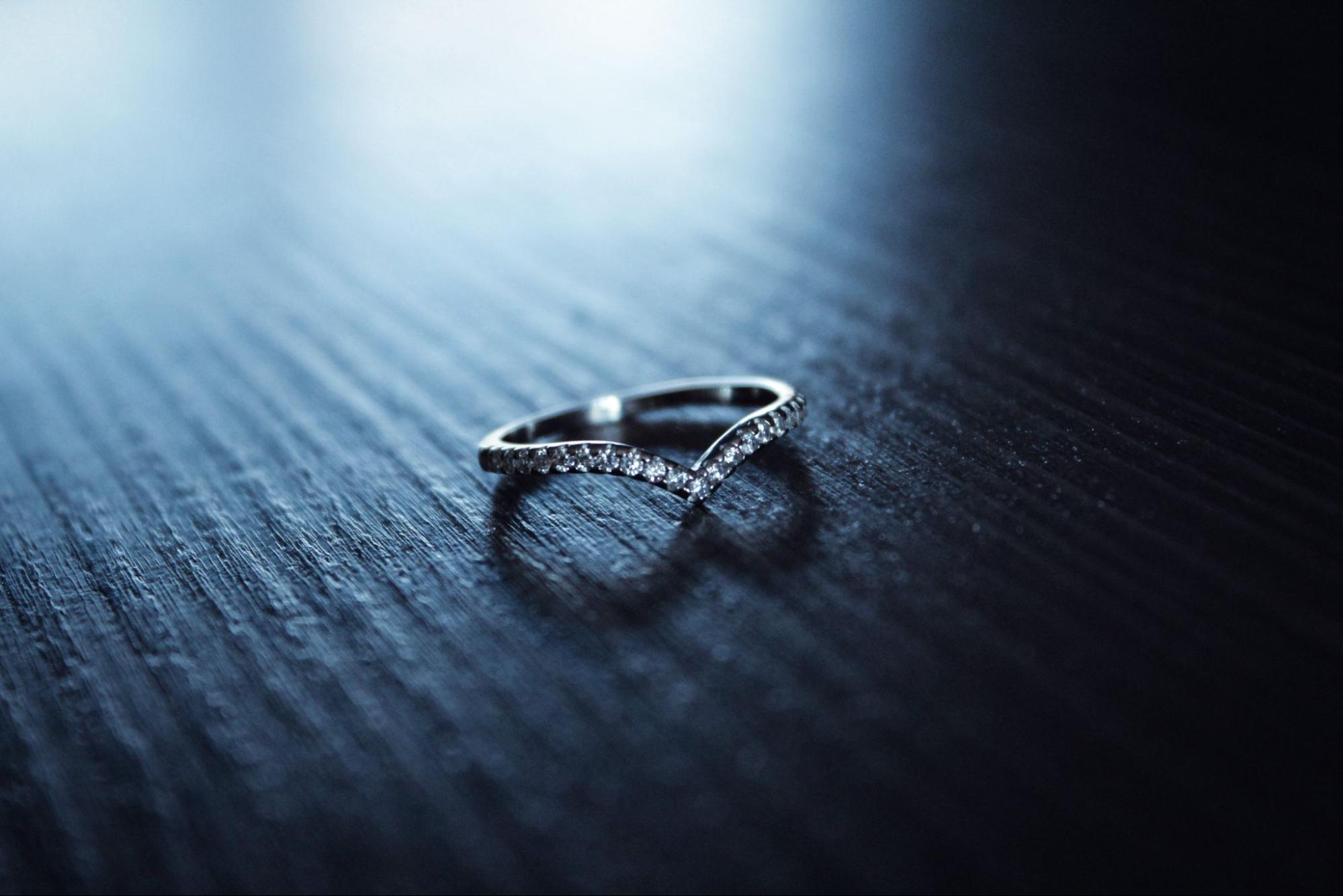 A close-up of a unique wedding band in low light.